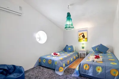 two beds in a white room with blue sheets at Country House Quinta da Ilda in Loulé