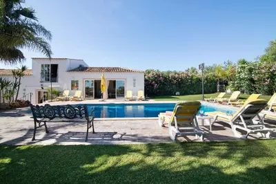a group of chairs sitting next to a swimming pool at Country House Quinta da Ilda in Loulé
