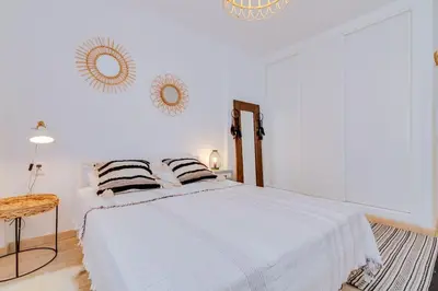 a bedroom with a white bed with two pillows at Downtown Bingo Apartment in Faro