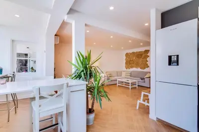 a kitchen and living room with a white table and chairs at Downtown Bingo Apartment in Faro