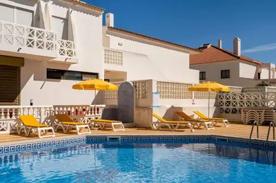 a pool with chairs and umbrellas next to a house at Double ROOFTop Mont-Blanc : vue plage amazing in Albufeira
