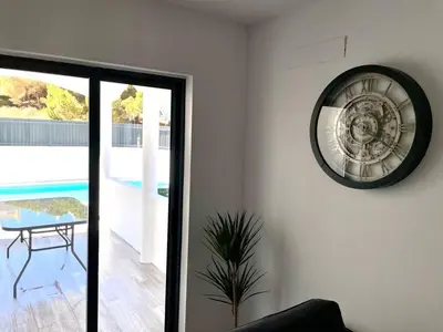 a clock on a white wall in a living room at V8 Praia da Falésia, Albufeira in Olhos de Água