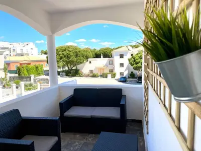a balcony with a couch and a plant at V8 Praia da Falésia, Albufeira in Olhos de Água