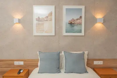 a bedroom with two lamps and a bed with blue pillows at Faro Heart Suites in Faro