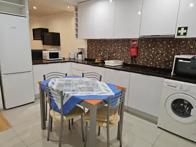 a kitchen with a table and a washing machine at Blife Joanya private apartment in Faro