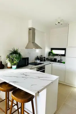 a kitchen with a white counter and stools in it at Sea View, Beach 3 minutes in Albufeira
