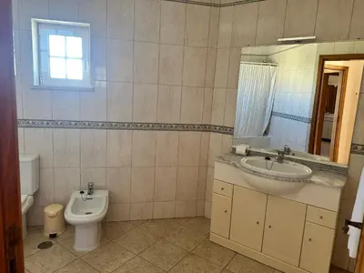 a bathroom with a sink and a toilet and a mirror at Benvindo Villa by Umbral in Albufeira