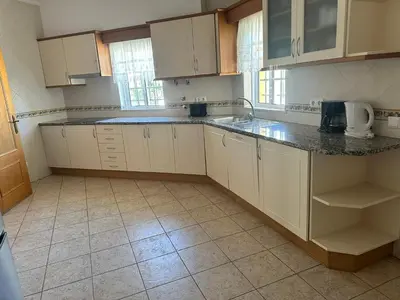 a kitchen with white cabinets and granite counter tops at Benvindo Villa by Umbral in Albufeira