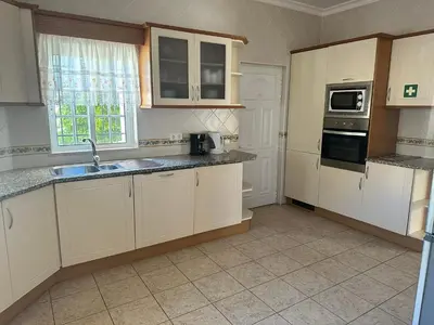 a kitchen with white cabinets and a sink at Benvindo Villa by Umbral in Albufeira