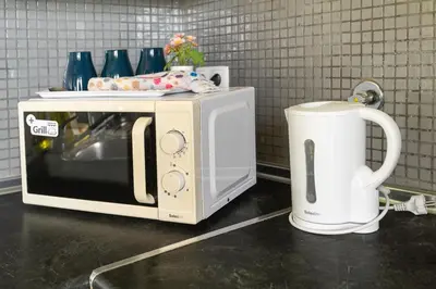 a microwave sitting on a counter next to a coffee pot at Blife Bandaya private apartment in Faro