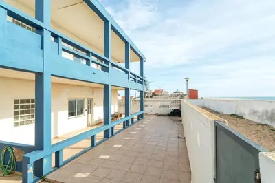 a blue and white building next to the beach at Blife Bandaya private apartment in Faro