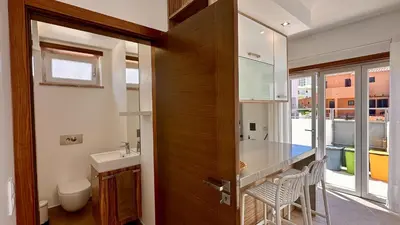 a bathroom with a sink and a wooden door at Lotus by Check-in Portugal in Quarteira