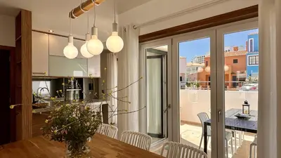 a kitchen and dining room with a table and chairs at Lotus by Check-in Portugal in Quarteira