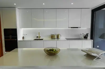 a white kitchen with a bowl of fruit on a counter at Buganvilia - Luxury villa - private pool by HD in Vale Formoso