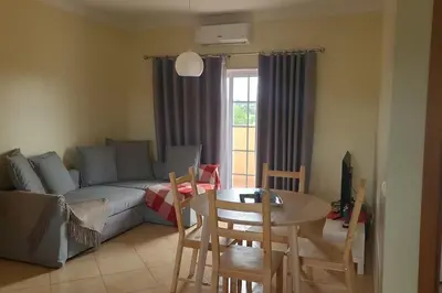 a living room with a couch and a table and chairs at Stela ' s Guest House in Loulé