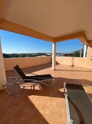 a chair sitting on top of a balcony at Stela ' s Guest House in Loulé