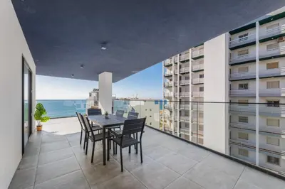 a dining room with a table and chairs on a balcony at Terracos de Quarteira Blue by Real Properties in Quarteira