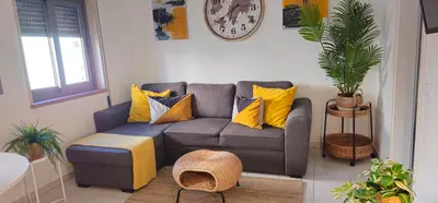 a living room with a gray couch with yellow pillows at Casa dos Sinos 2Bedroom Beach Apartment with Terrace in Albufeira