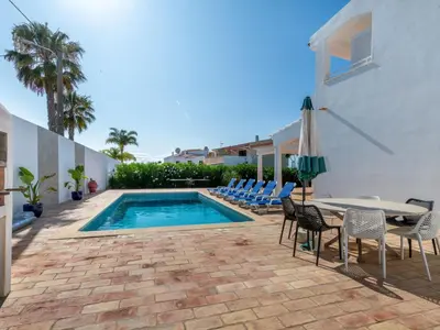 a patio with a table and chairs and a swimming pool at Villa Villa dos Sonhos V3 Lucia-VIP Properties by Interhome in Galé