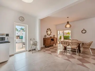a kitchen and dining room with a table and chairs at Villa Villa dos Sonhos V3 Lucia-VIP Properties by Interhome in Galé