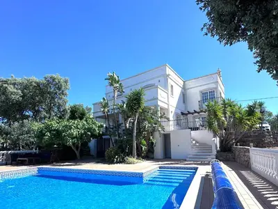 a villa with a swimming pool in front of a house at Algarve country villa near Loulé, stunning views in Romão
