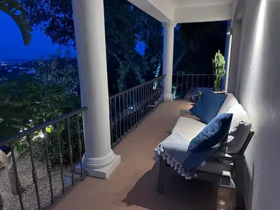 a porch with a couch and pillows on a balcony at night at Algarve country villa near Loulé, stunning views in Romão