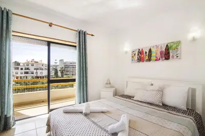 a bedroom with a bed and a large window at Hilcity in Albufeira