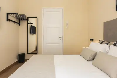 a bedroom with a white bed and a mirror at City Rooms Guest House by HD in Faro