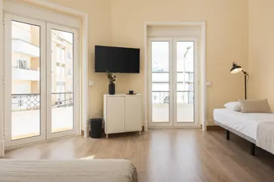 a bedroom with two beds and a flat screen tv at City Rooms Guest House by HD in Faro