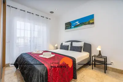 a bedroom with a bed with a sign that says love holidays at #228 Garrett Flats by Home Holidays in Albufeira