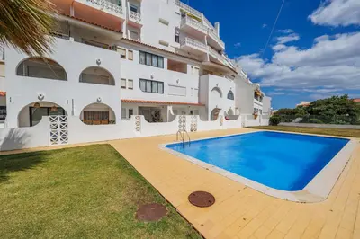 a villa with a swimming pool in front of a building at Helena's House Sea View in Albufeira