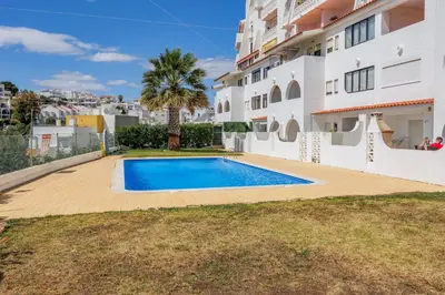 a swimming pool in front of a building at Helena's House Sea View in Albufeira
