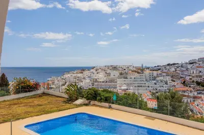 a villa with a swimming pool and a view of a city at Helena's House Sea View in Albufeira