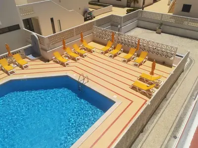 an overhead view of a swimming pool with yellow lounge chairs and a swimming pool at OURA WHITE VIEW Beach 2 min walk sea in Albufeira