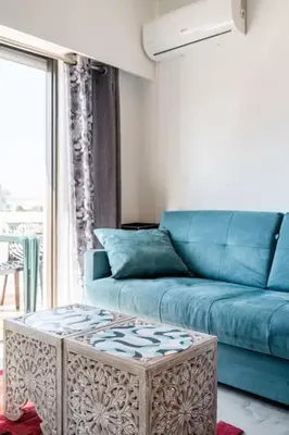 a living room with a blue couch and a coffee table at OURA WHITE VIEW Beach 2 min walk sea in Albufeira