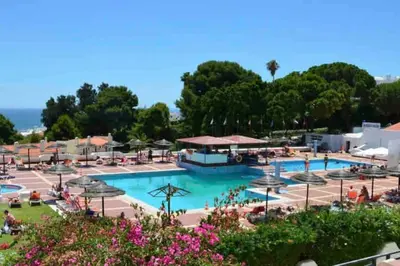 a large swimming pool with tables and umbrellas at ELdorado JArdim open view beach 5 minutes foot in Albufeira