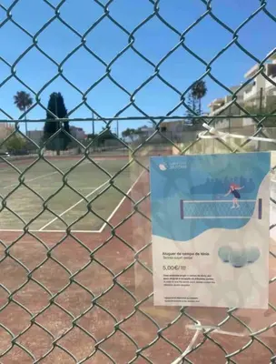 a sign on a fence in a baseball field at ELdorado JArdim open view beach 5 minutes foot in Albufeira
