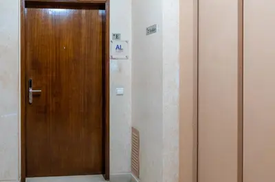 a wooden door in a hallway in a building at Blife Ricardya private rooms in Faro