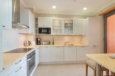 a kitchen with white cabinets and a counter top at The Residences Vilamoura, Apartment Melissa in Vilamoura