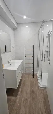 a white bathroom with a sink and a shower at Faro Main Avenue Apartment II in Faro