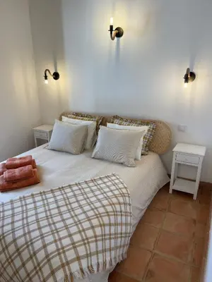 a bedroom with a large bed with two pillows at Monte Gerações - Heated pool - Typical Algarvian - close to Quinta Lago, Vale Lobo and Vilamoura in Almancil