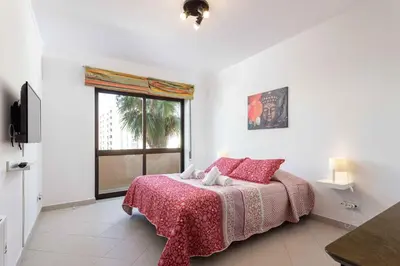 a bedroom with a bed with a red blanket and a window at Blife Amorya private apartment in Faro