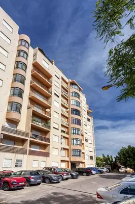 a large building with cars parked in a parking lot at Blife Amorya private apartment in Faro