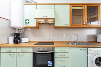 a kitchen with white cabinets and a sink at Blife Amorya private apartment in Faro