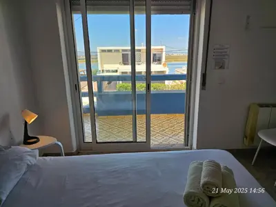 a bedroom with a bed and a view of a balcony at Blife Ceriya private apartment in Faro