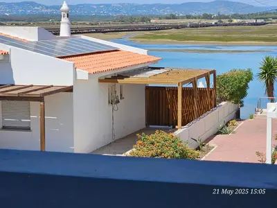 a house with a solar roof with a lighthouse in the background at Blife Ceriya private apartment in Faro