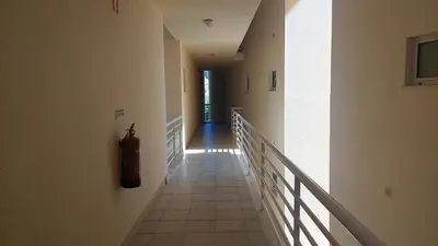 a hallway in a building with a fire extinguisher on the wall at Vilamoura TOP MouraPraia in Vilamoura