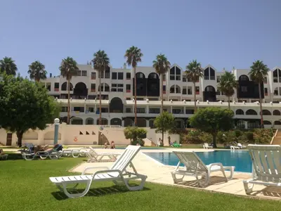 an aerial view of a resort with a swimming pool and palm trees at Jeannie's Oura Estrela in Albufeira