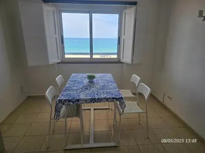 a dining room with a table and chairs and the ocean at Blife Vistaya private apartment in Faro