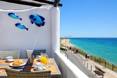 a table on a balcony with a view of the ocean at Beach Residence Old Town in Albufeira